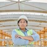 Female construction worker wearing a hard hat on site