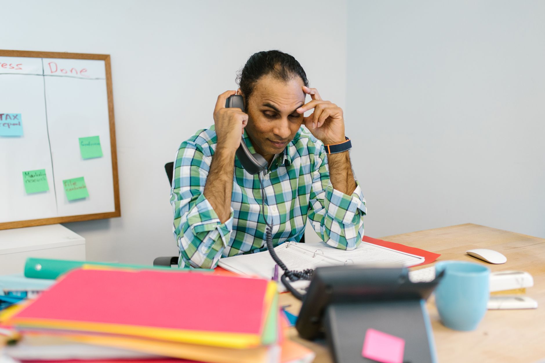 A construction leader taking a call under pressure on site