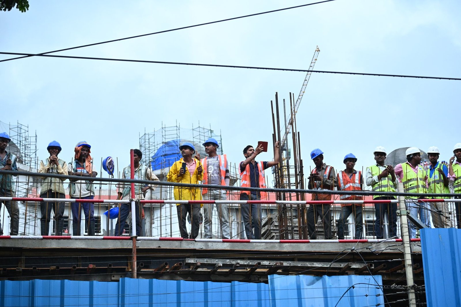 A construction supervisor stepping back and watching his crew work