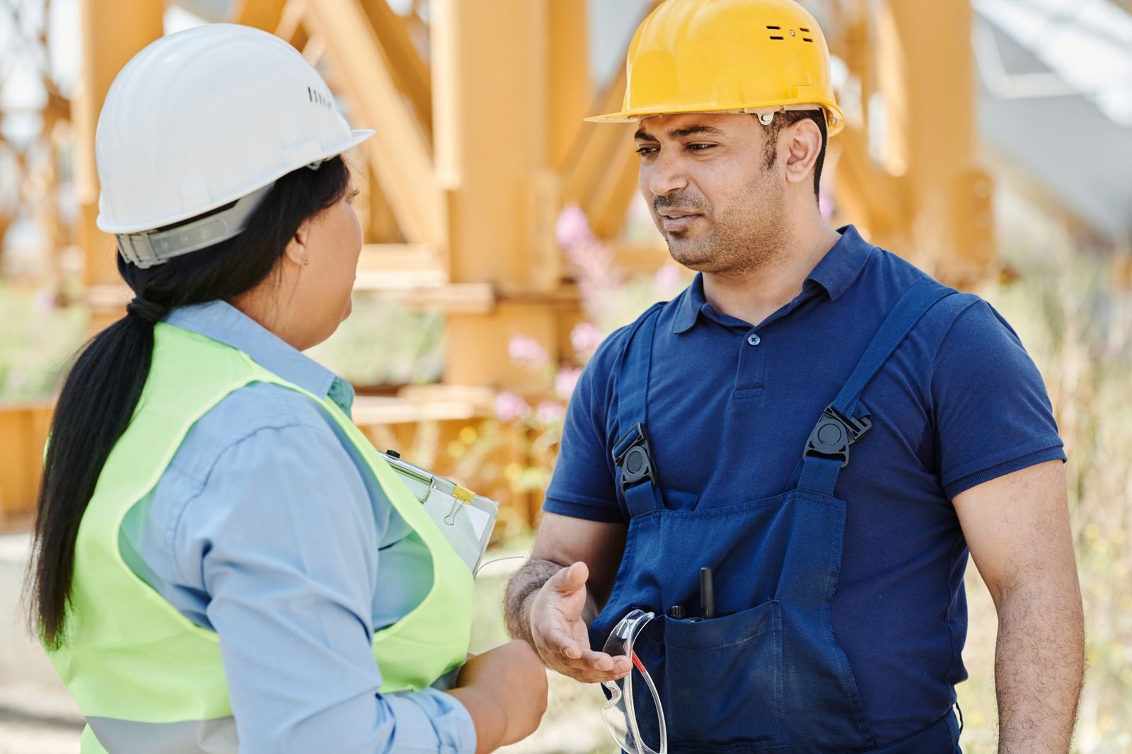Two construction workers in a serious one to one conversation on site