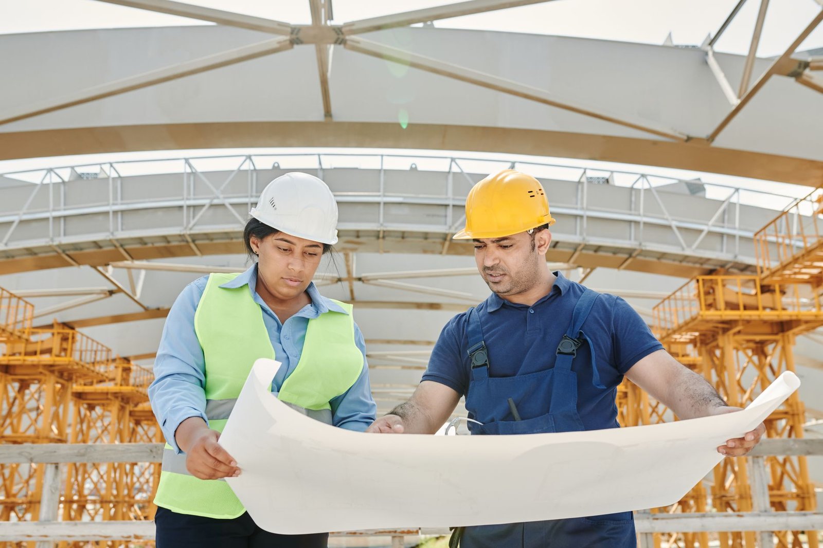 Two construction workers reviewing drawings together on a work front
